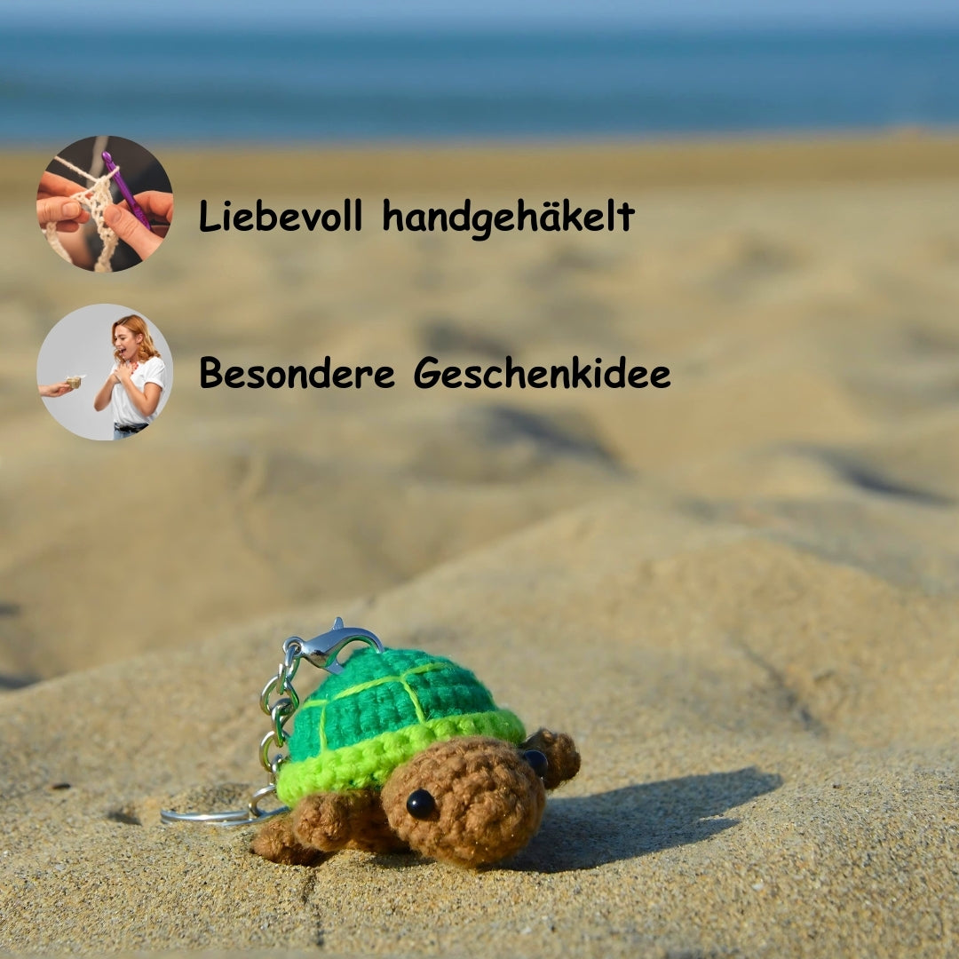 grün brauner Schildkrötenanhänger am Strand